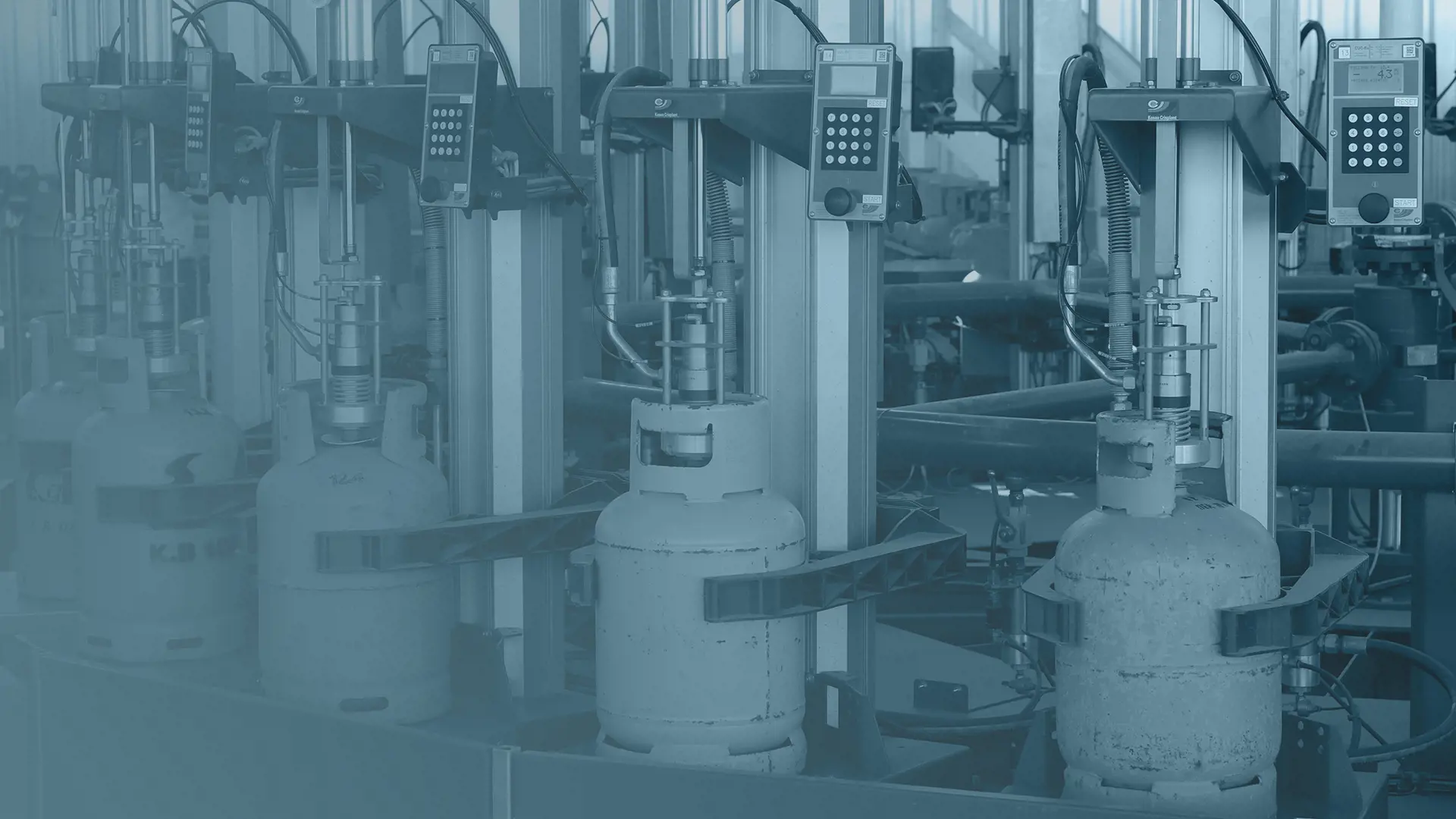 blue toned image of lpg cylinders on a filling carrousel