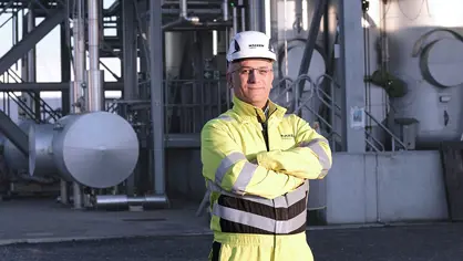 Man standing in yellow safety clothing and helmet