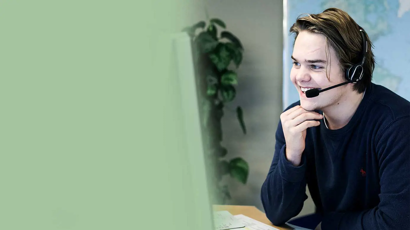 Young guy with a headset sitting in front of a computer screen